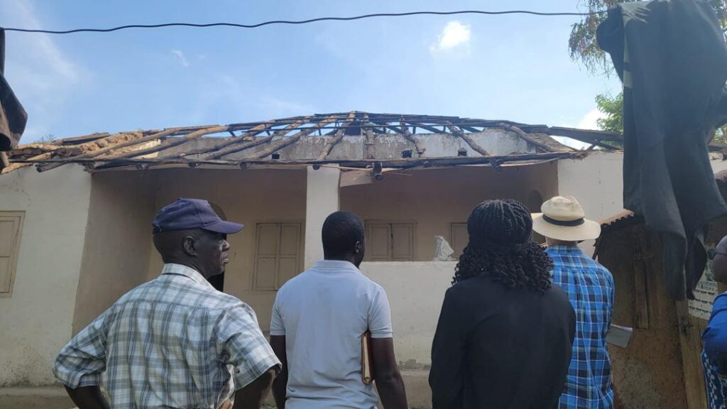 The CCFU team inspect the roof of one of the buildings at the Semei Kakungulu site. (c) Cross-Cultural Foundation of Uganda. 