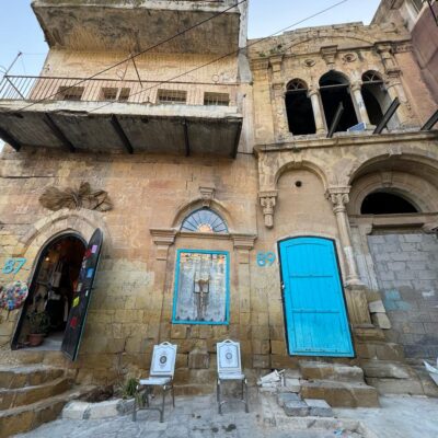 The entry to an old building in Amman, Jordan with a bright turquoise door
