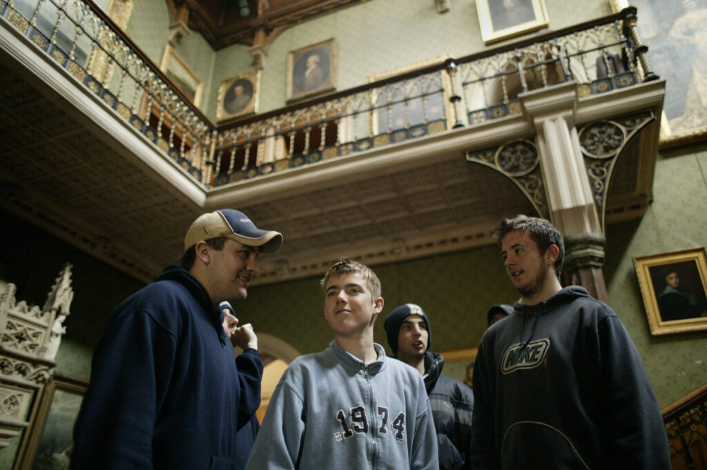 a small group of teenage boys in an historic house interior