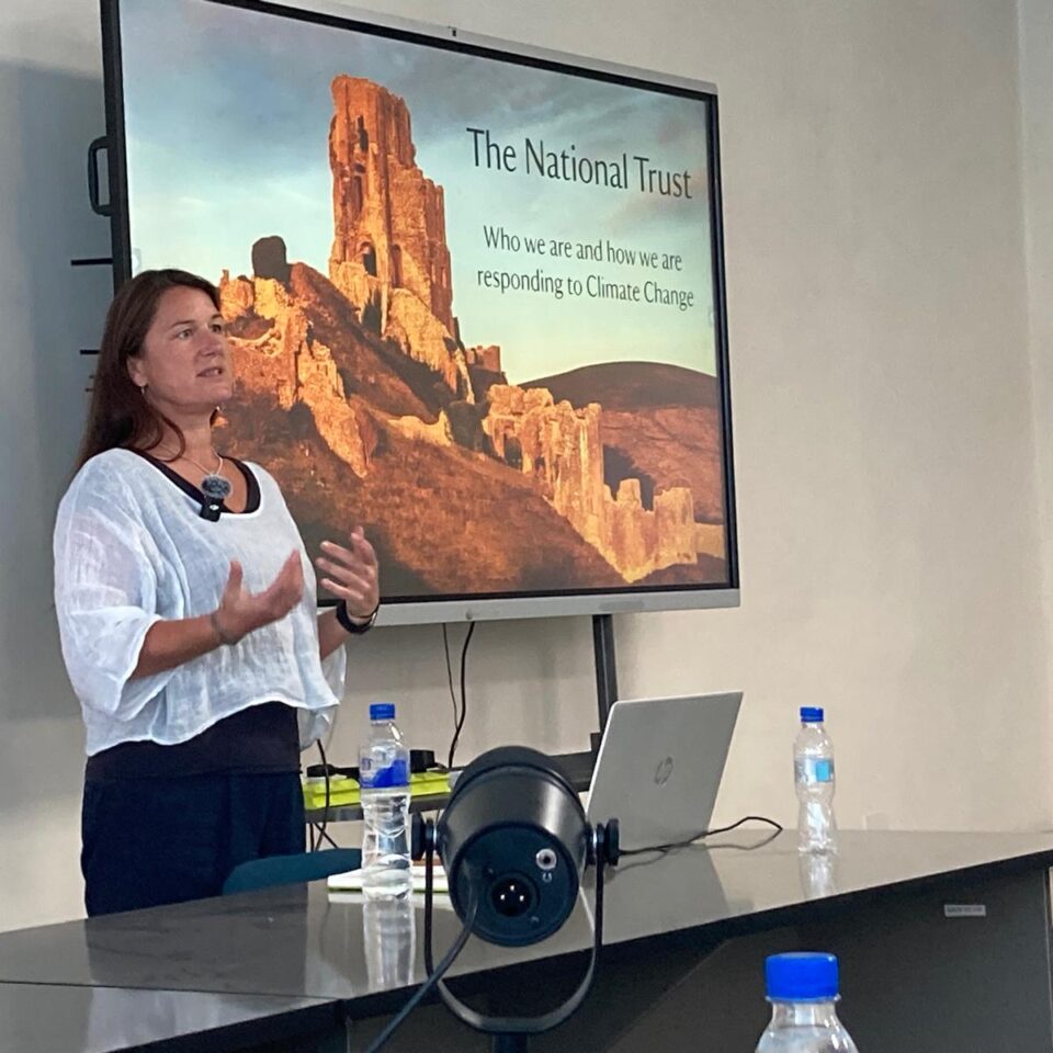 a woman presenting slide on a large screen