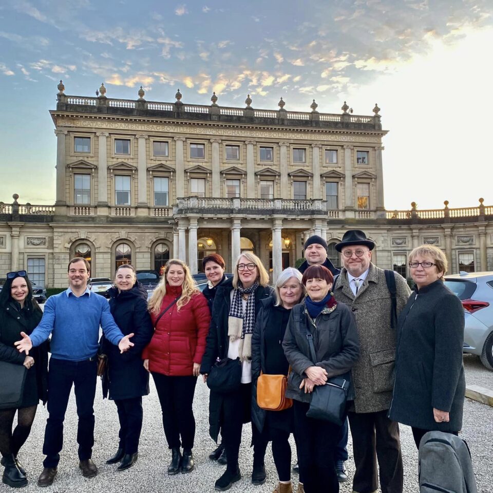 A group of people standing in front of a large historic building